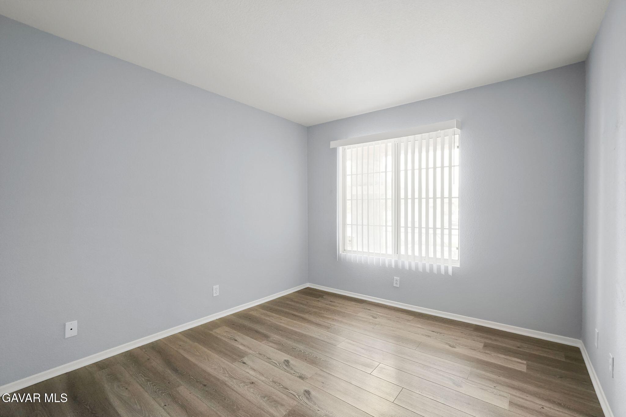 2108 Manchester Street Rosamond, CA 93560 - Photo 24 of 41 an empty room with wooden floor and windows