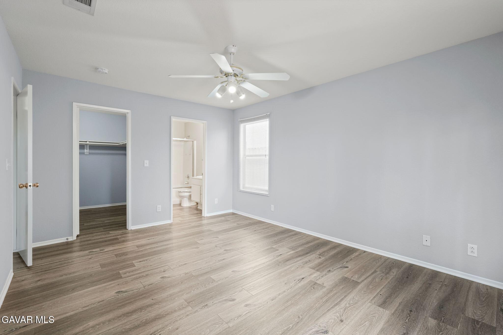 2108 Manchester Street Rosamond, CA 93560 - Photo 28 of 41 an empty room with wooden floor fan and windows