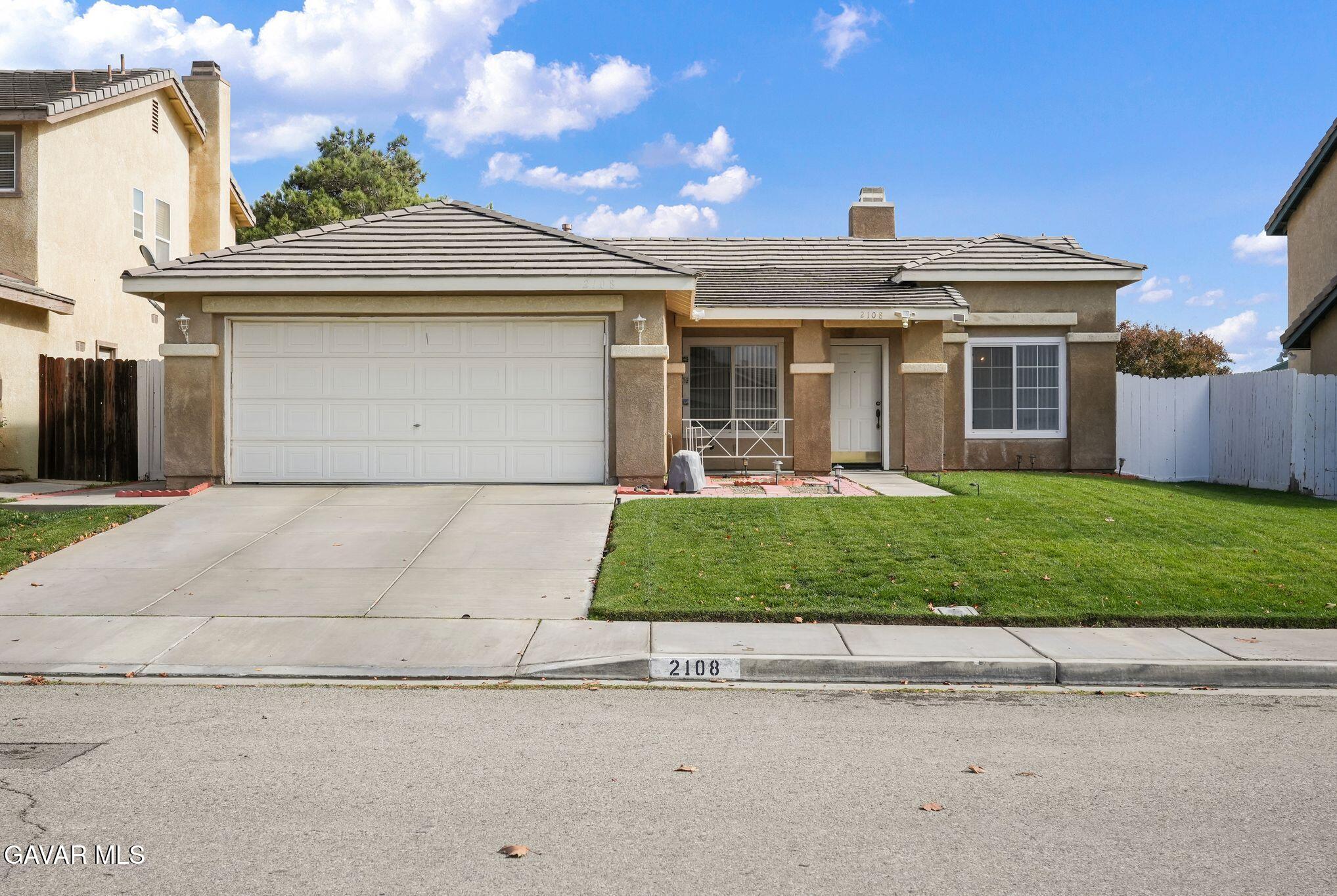 2108 Manchester Street Rosamond, CA 93560 - Photo 9 of 41 a front view of a house with a garden and plants