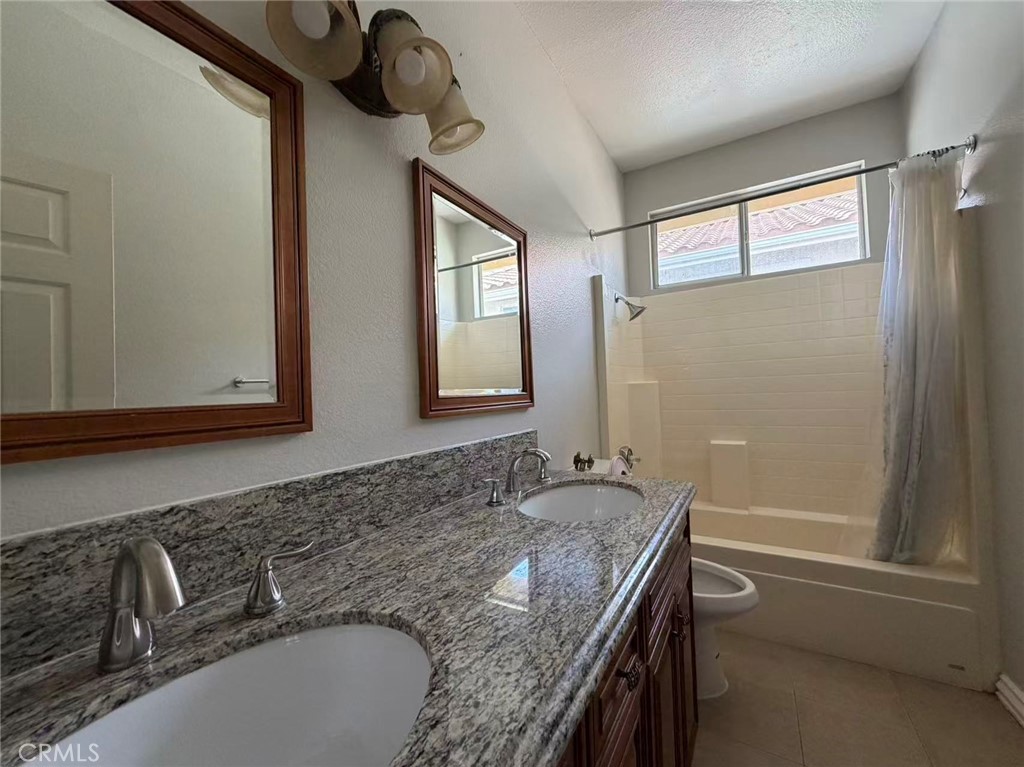 7162 Breno Place Rancho Cucamonga, CA 91701 - Photo 15 of 20 a bathroom with a granite countertop sink and a mirror