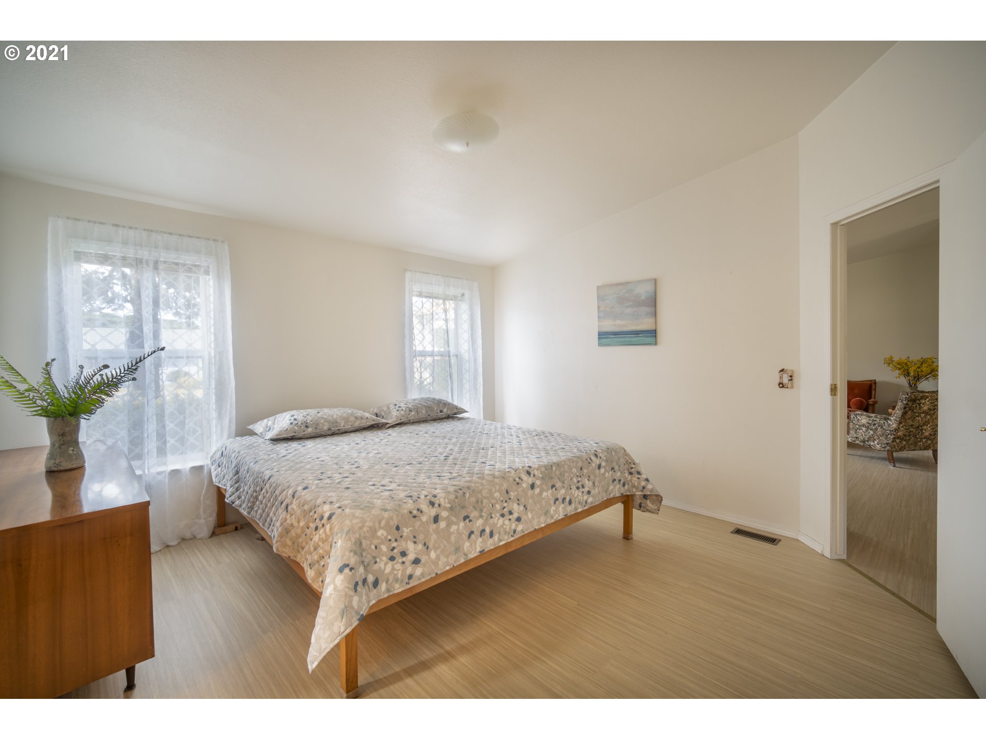 887 Jackson Avenue Southwest Bandon, OR 97411 - Photo 11 of 20 a bedroom with a bed and a potted plant
