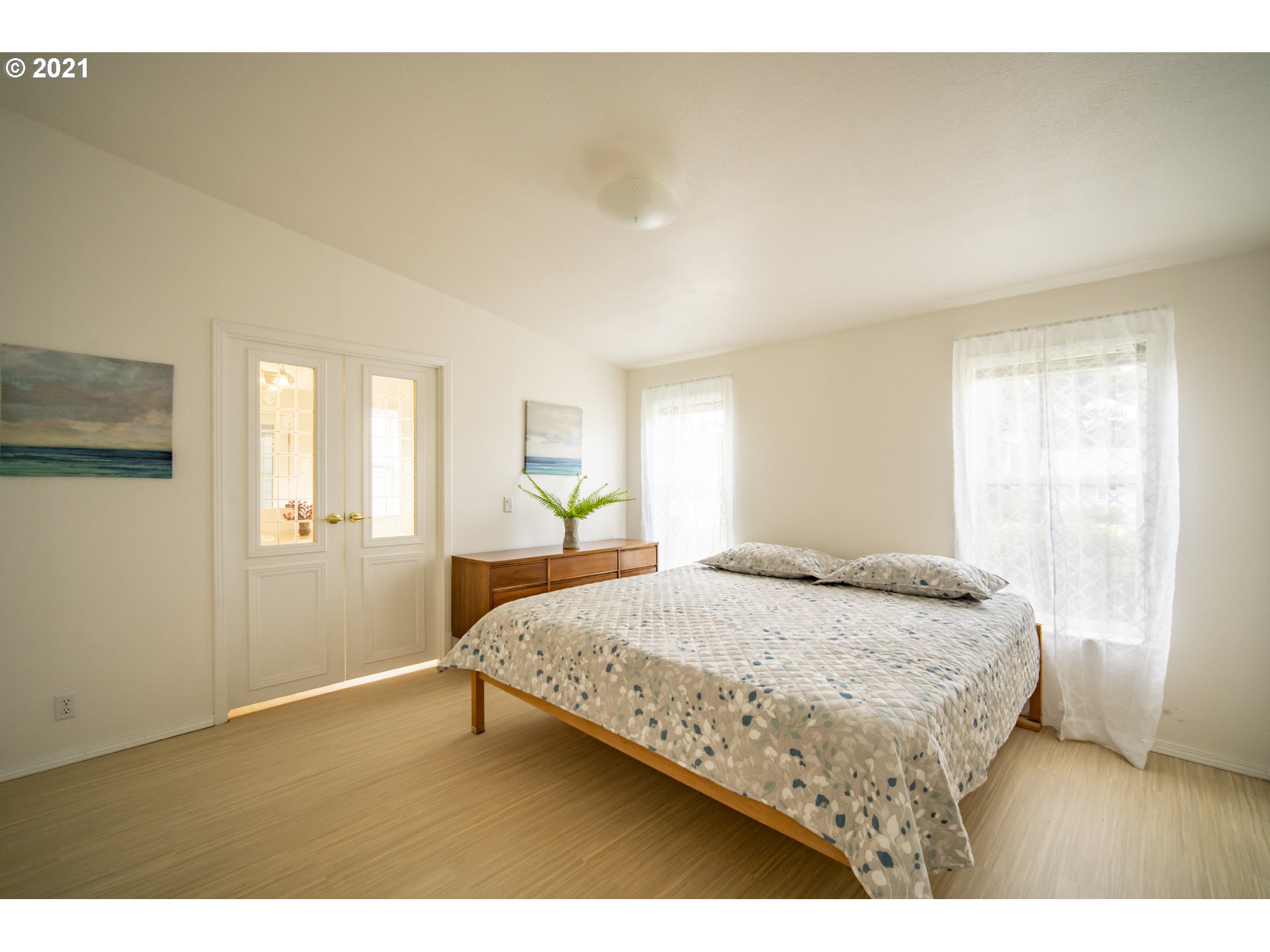 887 Jackson Avenue Southwest Bandon, OR 97411 - Photo 12 of 20 a bedroom with a bed and wooden floor