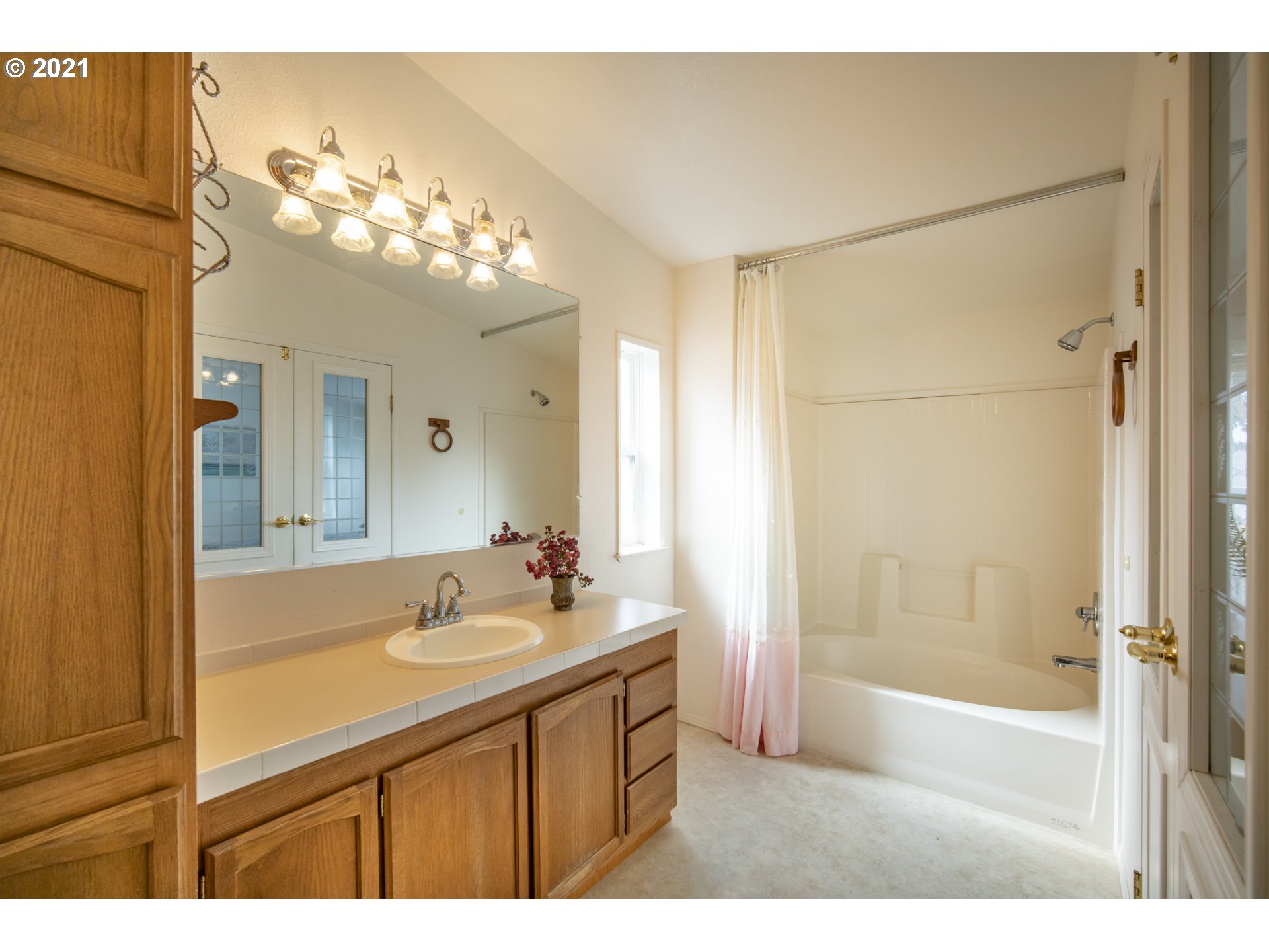 887 Jackson Avenue Southwest Bandon, OR 97411 - Photo 13 of 20 a bathroom with a sink mirror and a bathtub