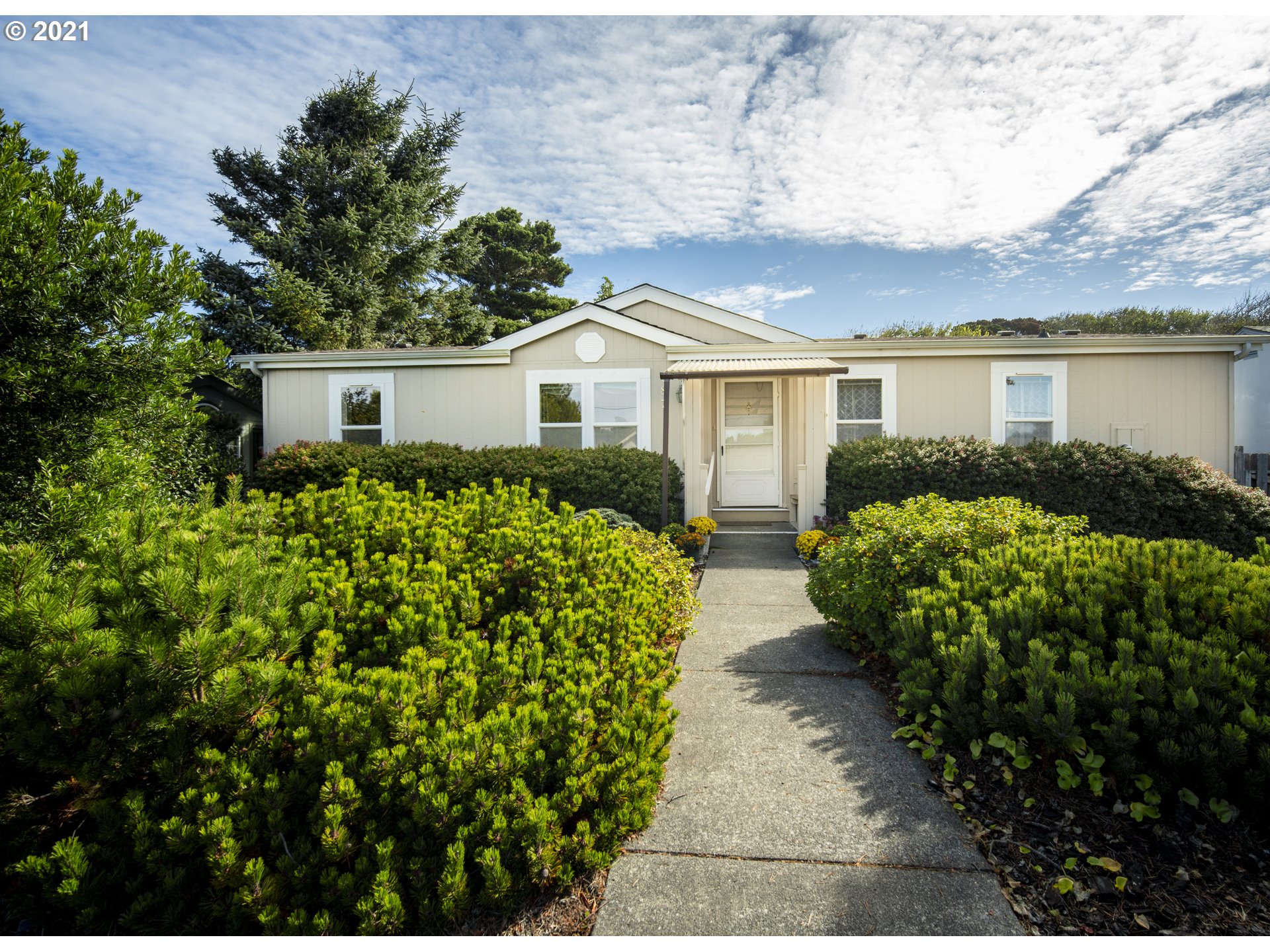 887 Jackson Avenue Southwest Bandon, OR 97411 - Photo 3 of 20 a front view of a house with a garden