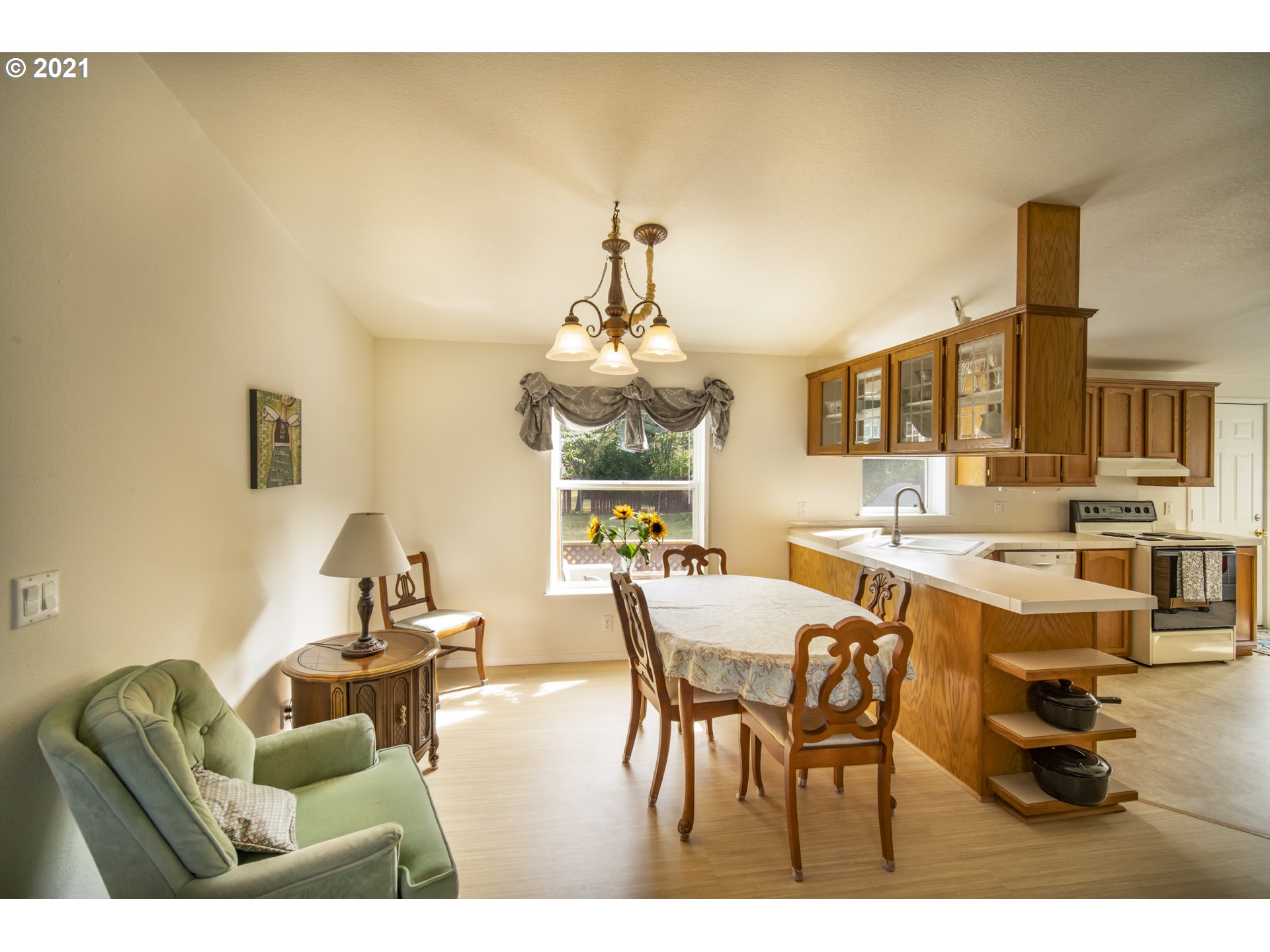 887 Jackson Avenue Southwest Bandon, OR 97411 - Photo 7 of 20 a living room with fireplace furniture and a chandelier