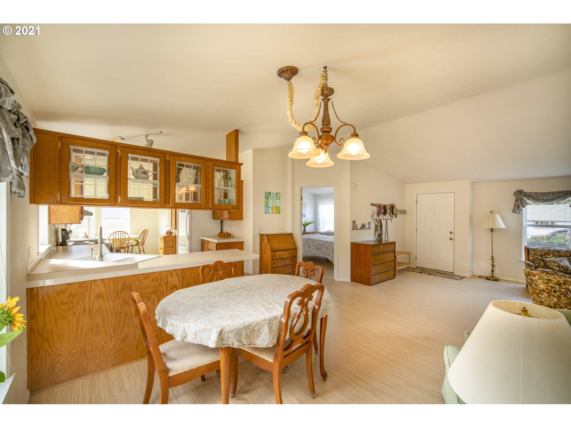 887 Jackson Avenue Southwest Bandon, OR 97411 - Photo 8 of 20 a living room with furniture a chandelier and a dining table