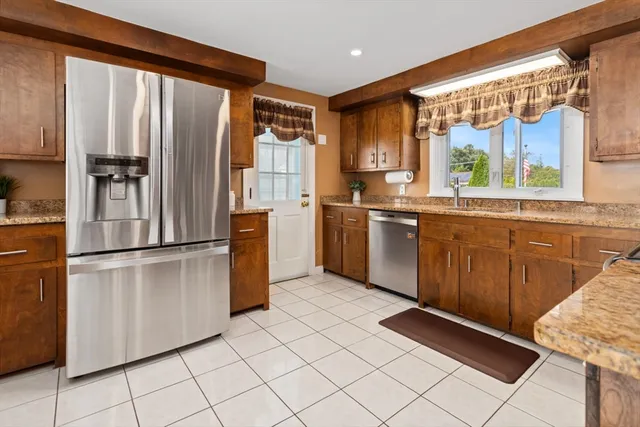 a kitchen with stainless steel appliances granite countertop a refrigerator and a sink