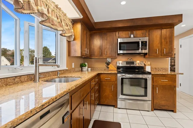 a kitchen with a sink a counter top space cabinets and stainless steel appliances