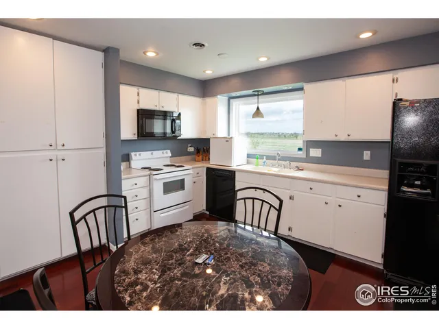 a kitchen with white cabinets a sink a stove and a refrigerator