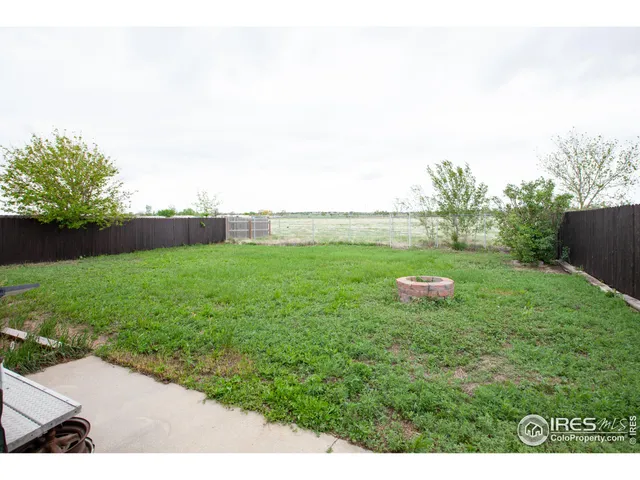 a backyard of a house with plants and large trees