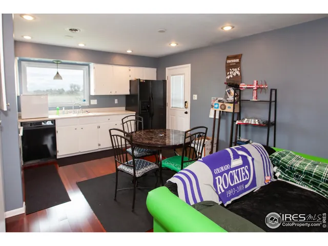 a living room with furniture a flat screen tv and kitchen view