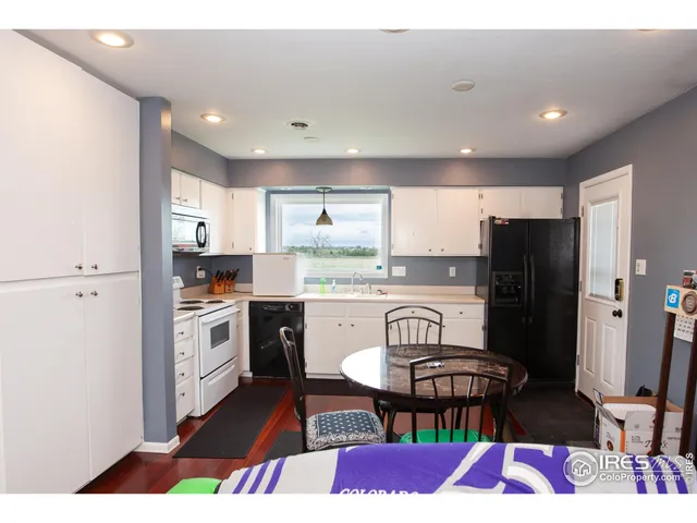 a kitchen with a refrigerator a stove a sink dishwasher with a dining table and chairs