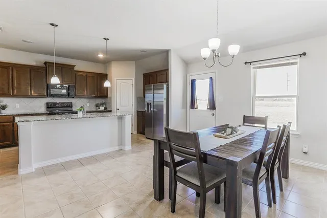 a kitchen with a table chairs and white cabinets
