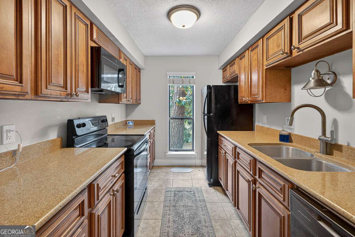 2514 Demere Road, Unit 7 St. Simons, GA 31522 - Photo 14 of 22 a kitchen with stainless steel appliances granite countertop a sink stove and refrigerator