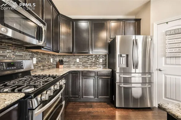 a kitchen with granite countertop stainless steel appliances and wooden cabinets