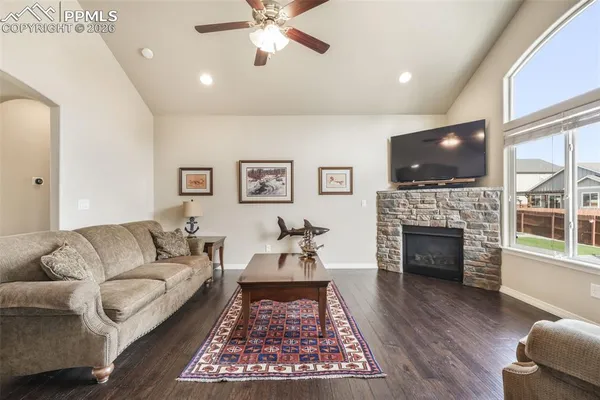 a living room with furniture a flat screen tv and a fireplace