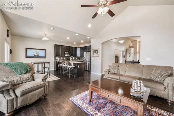 a living room with furniture and a view of kitchen