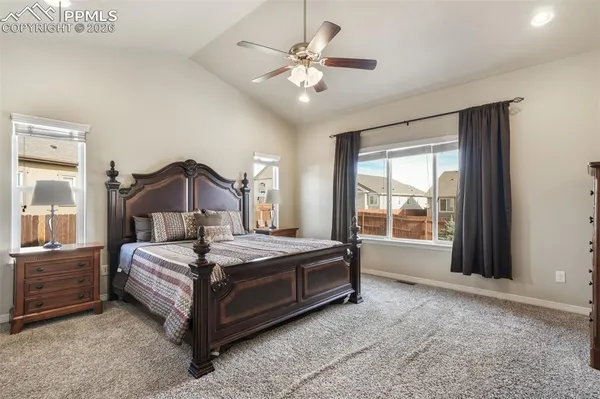 a bedroom with a bed and a large window with the outer view