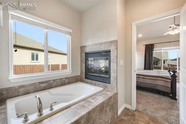 a bathroom with a tub a sink and a large window