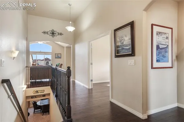 a view of a hallway with furniture and wooden floor