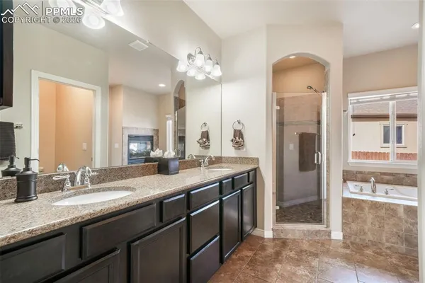 a spacious bathroom with a granite countertop sink a mirror and a shower