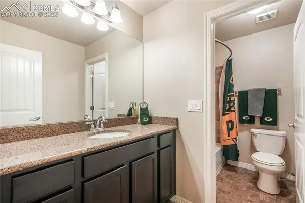 a bathroom with a granite countertop sink toilet and shower