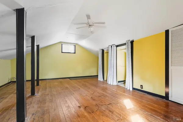 a view of a livingroom with wooden floor and a ceiling fan