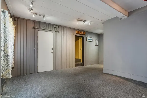 an empty room with closet and windows