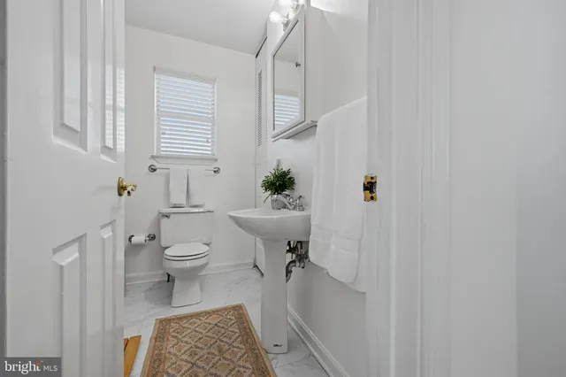 a bathroom with a sink a toilet and a window