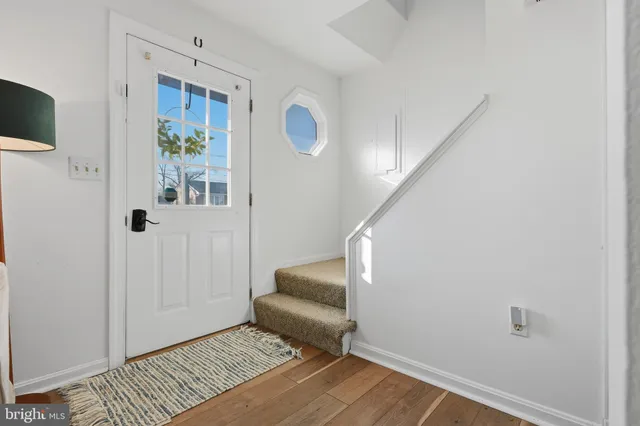 a view of a hallway with wooden floor and entryway