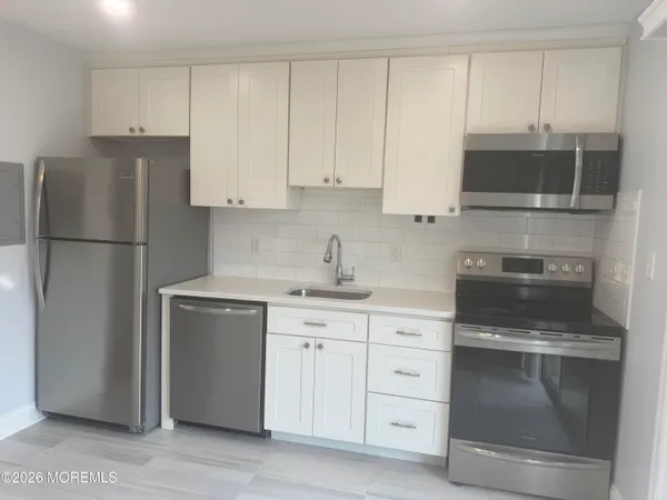 a kitchen with white cabinets and white appliances