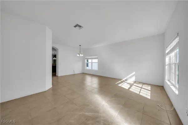 an empty room with a window and a ceiling fan