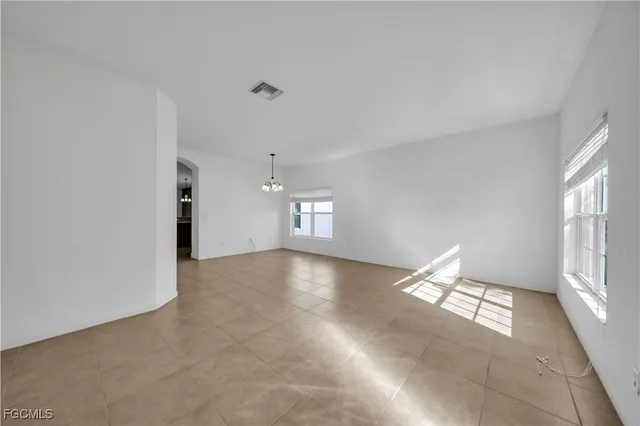 an empty room with a window and a ceiling fan