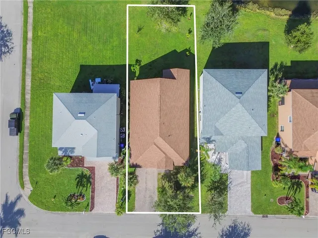 an aerial view of a house with a garden and lake view
