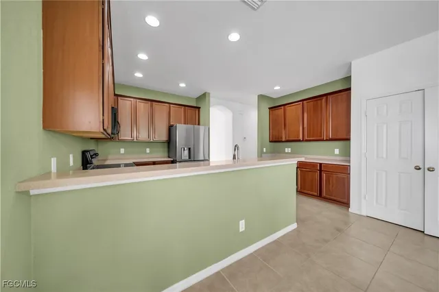 a kitchen with stainless steel appliances granite countertop a stove a sink and a refrigerator with wooden floor