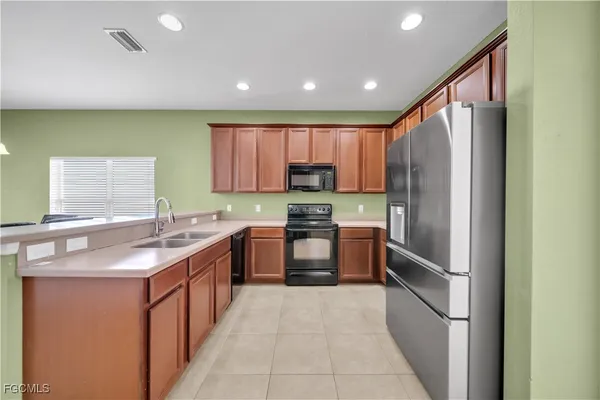 a kitchen with stainless steel appliances granite countertop refrigerator a sink a stove top oven and a dishwasher
