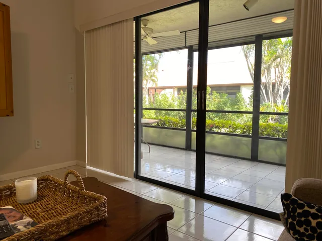 a view of a porch with furniture and floor to ceiling window