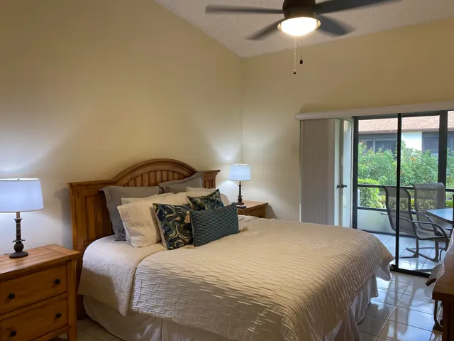 a bedroom with a bed and large windows