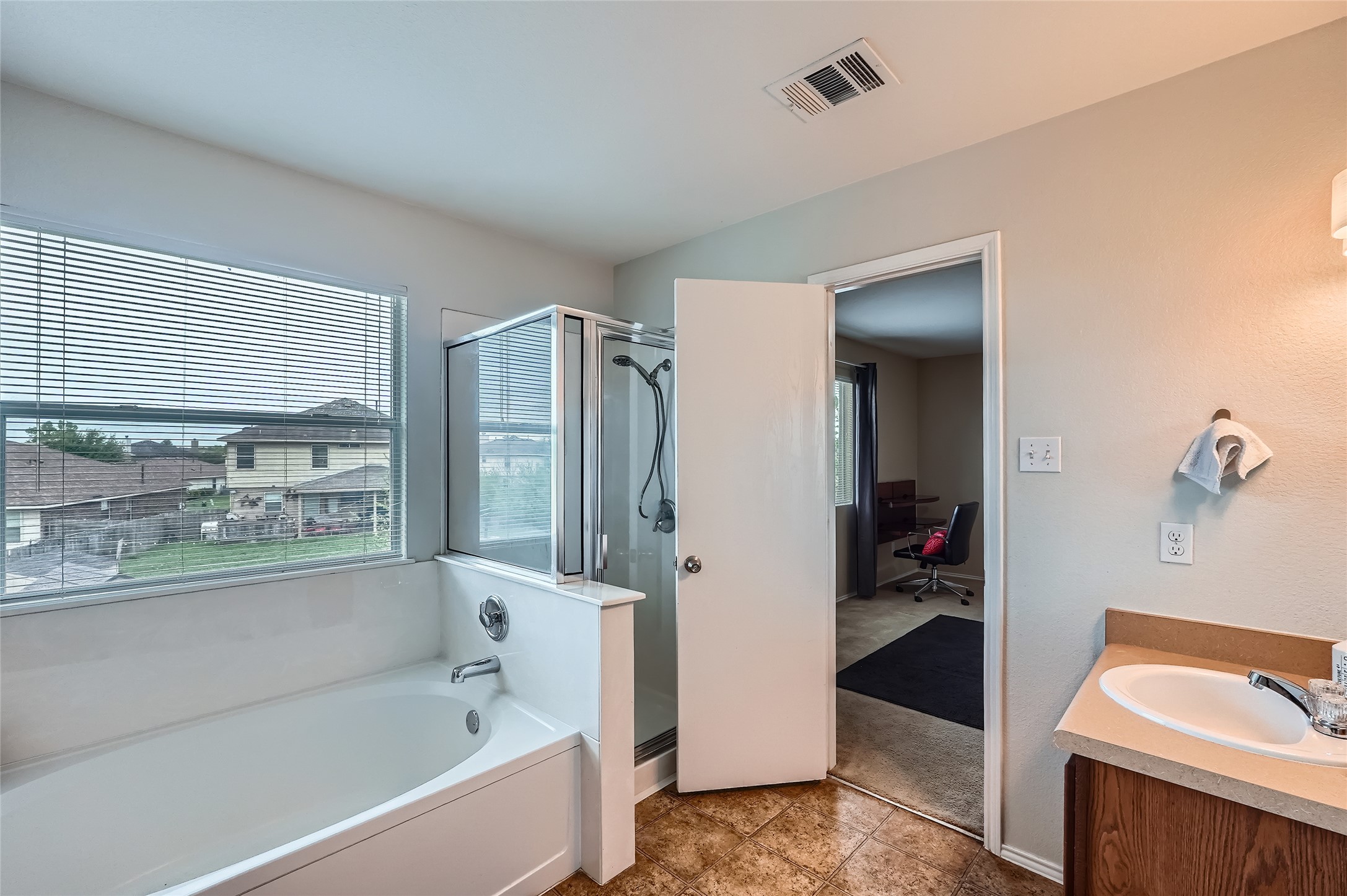 18021 Prairie Verbena Lane Elgin, TX 78621 - Photo 22 of 33 A well-appointed bathroom offers a deep soaking tub and a separate glass-enclosed shower.