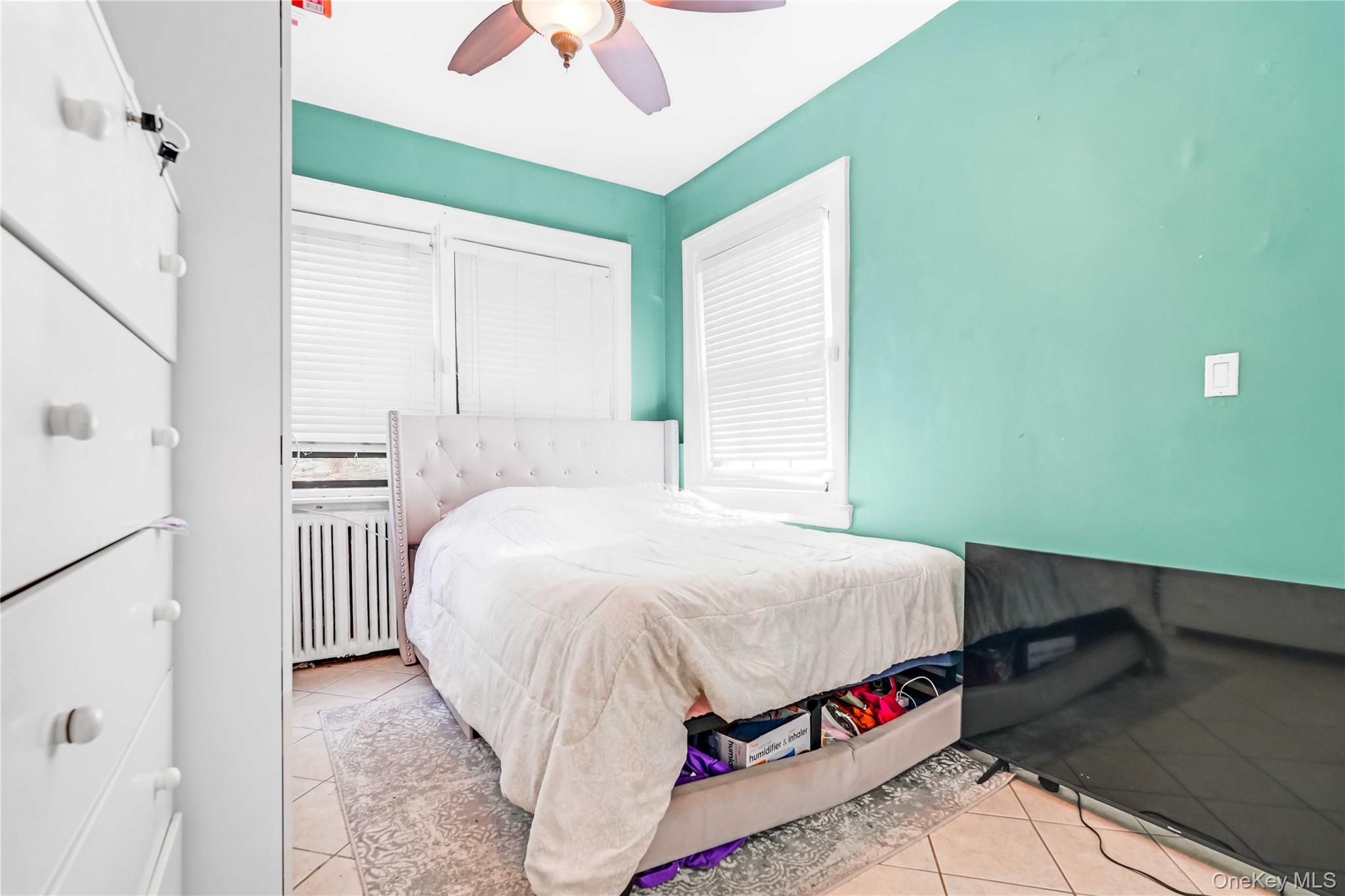 160-08 12th Road Queens, NY 11357 - Photo 17 of 28 a bedroom with a bed and a chandelier