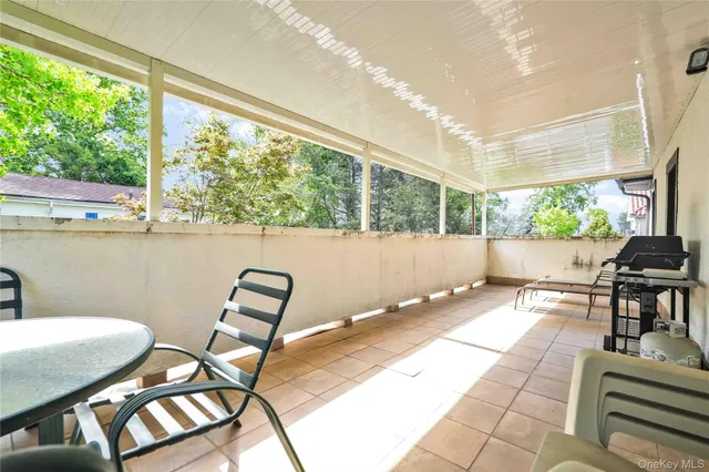 a view of a patio with a dining table and chairs with wooden floor