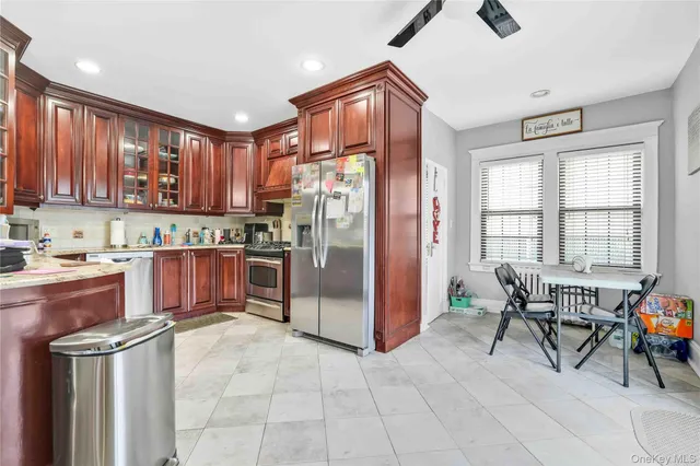 a kitchen with stainless steel appliances granite countertop a refrigerator and a stove top oven
