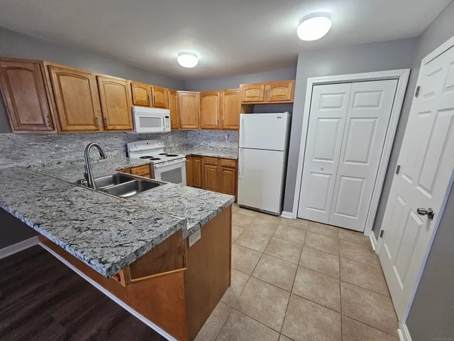 a kitchen with stainless steel appliances granite countertop a refrigerator oven a sink and dishwasher