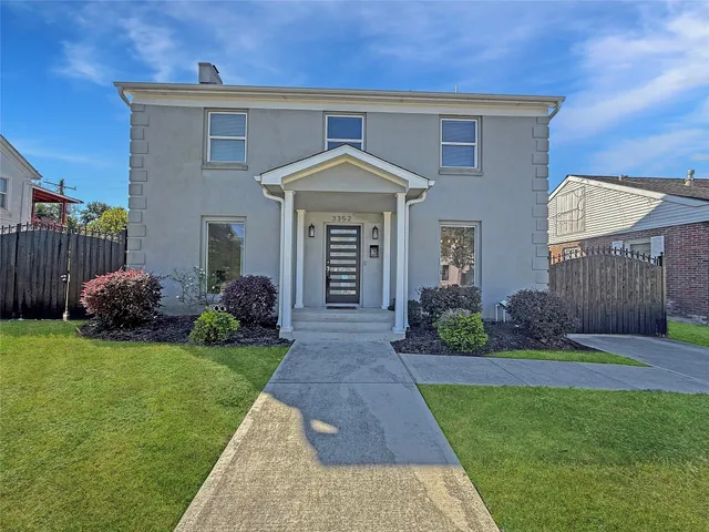 a front view of a house with a garden and yard