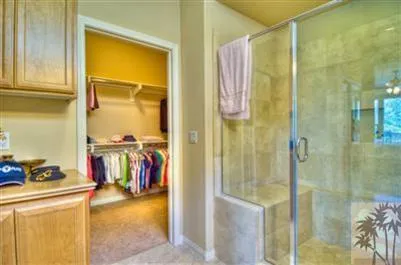 a view of walk in closet with clothes and shoes