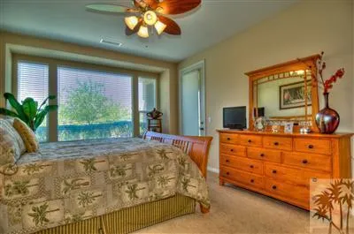 a bedroom with a bed chandelier and a large window