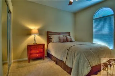 a bed sitting in a bedroom next to a lamp