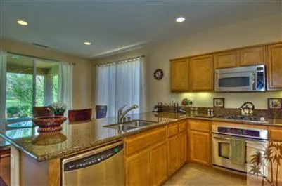 a kitchen with stainless steel appliances granite countertop a sink stove and cabinets