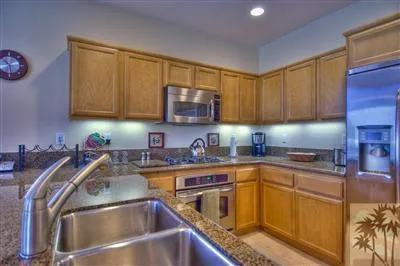 a kitchen with granite countertop a sink and a stove top oven