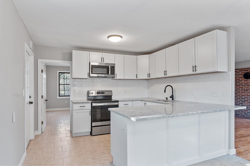 43 Hadley Road Merrimac, MA 01860 - Photo 7 of 19 a kitchen with stainless steel appliances granite countertop a sink stove and refrigerator